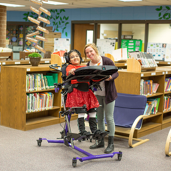 A happy children with RMS Easystand product to offer a better range of motion and security to her life